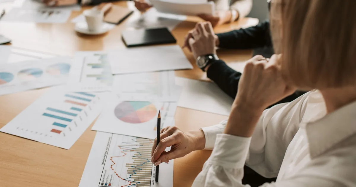 Profissionais da Ânima Educação analisam gráficos, com Vibra Energia e mercado financeiro em foco.