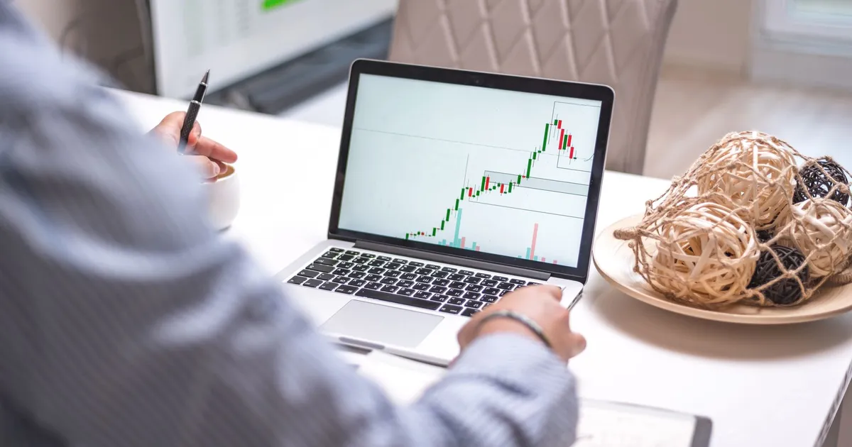 Análise de ações Suzano e Embraer em laptop, com Ibovespa e Day Trade em foco.