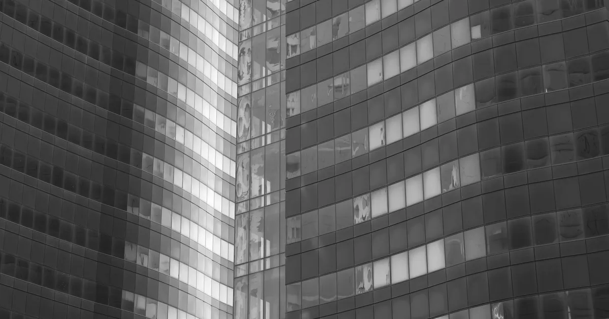 Arranha-céu moderno em cinza, estrutura financeira que reflete a política monetária do Banco Central sobre o Dólar.