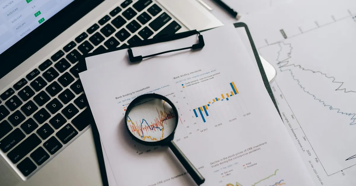 Gráficos financeiros e lupa para análise dos balanços Bradesco (BBDC4) e recomendações da XP no setor bancário.