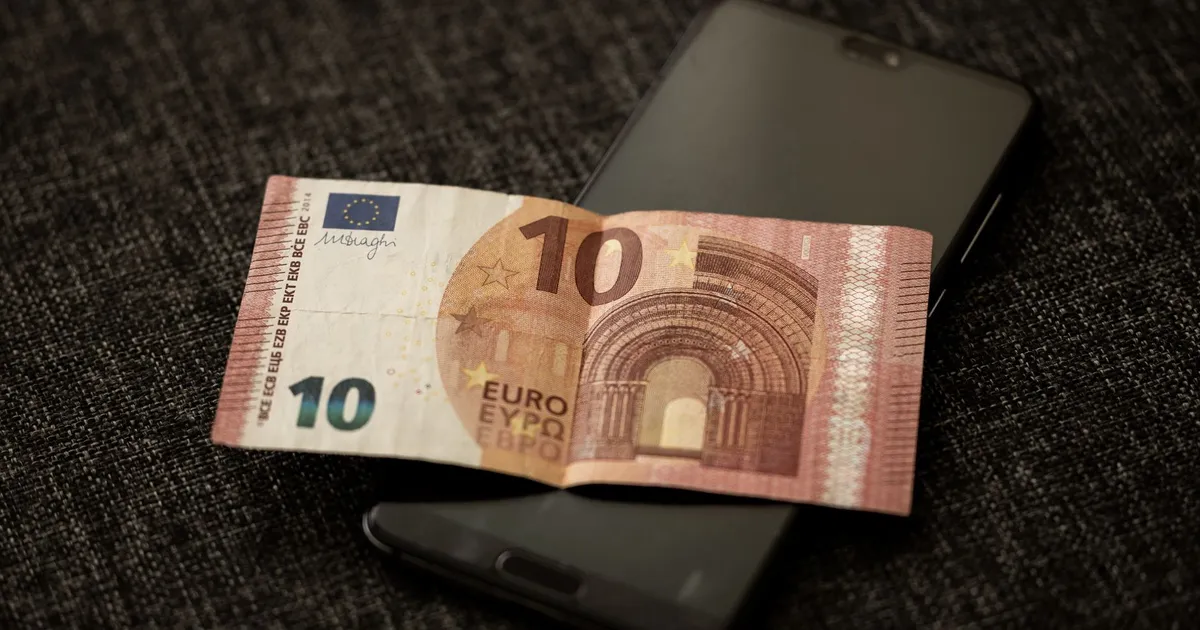 Bradesco turbina pagamentos EUA com Zelle; nota euro em smartphone simboliza pagamentos digitais.