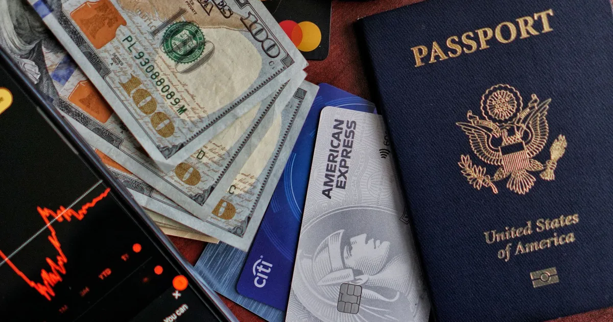 Passaporte EUA, dinheiro e smartphone com gráfico: Brasil impactado por tarifas e alta do petróleo.