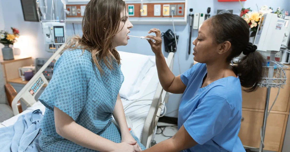 Enfermeira cuida paciente em enfermaria, ilustrando o alto custo do câncer de intestino em jovens no sistema de saúde.