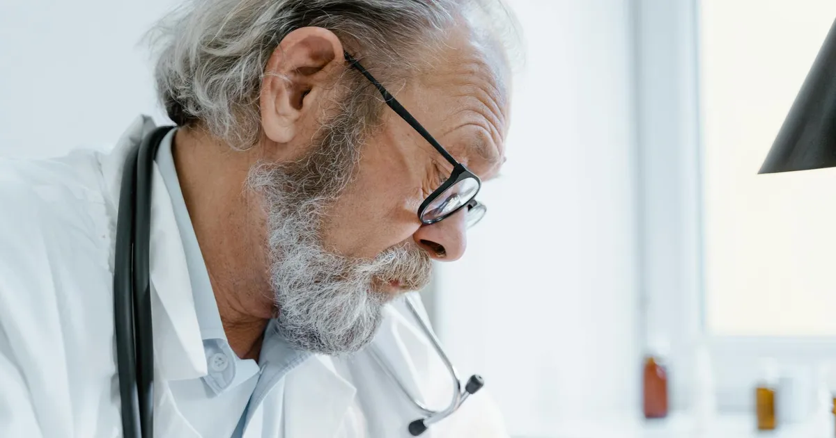 Médico sênior com óculos e estetoscópio. Essencial para a saúde de Lula e o futuro da presidência.