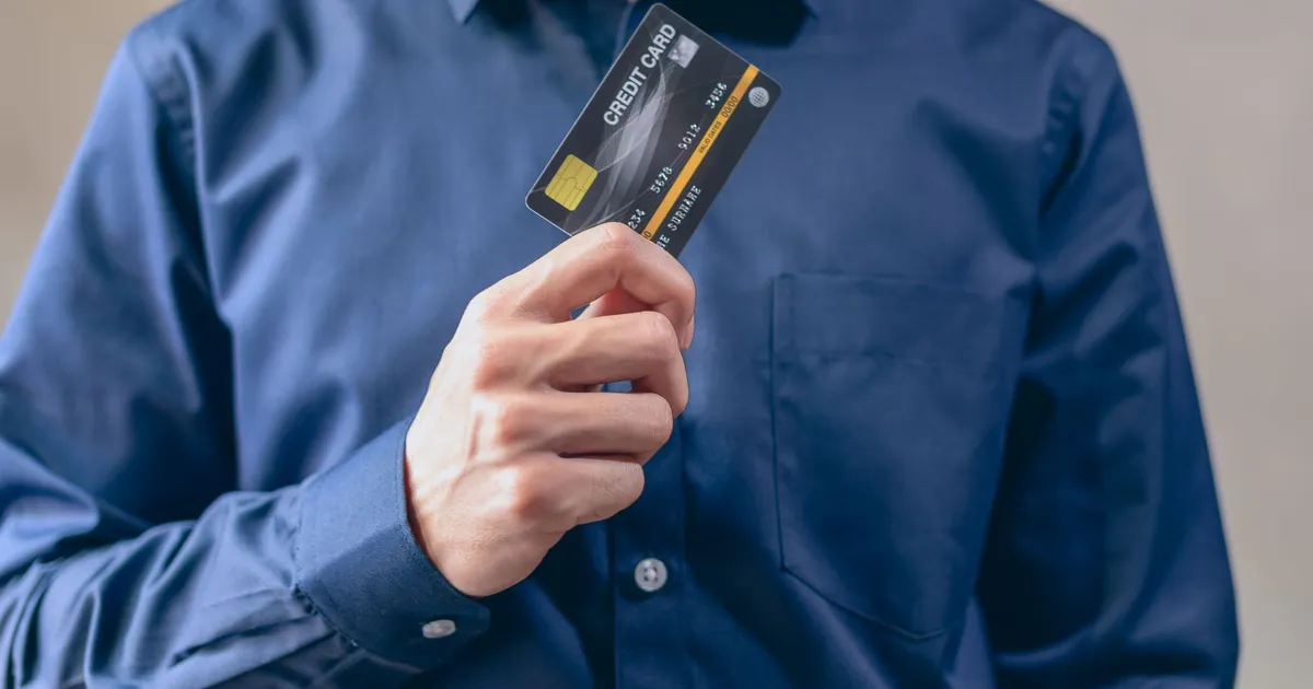 Homem com cartão de crédito, alertando sobre endividamento e limites, foco do BC.