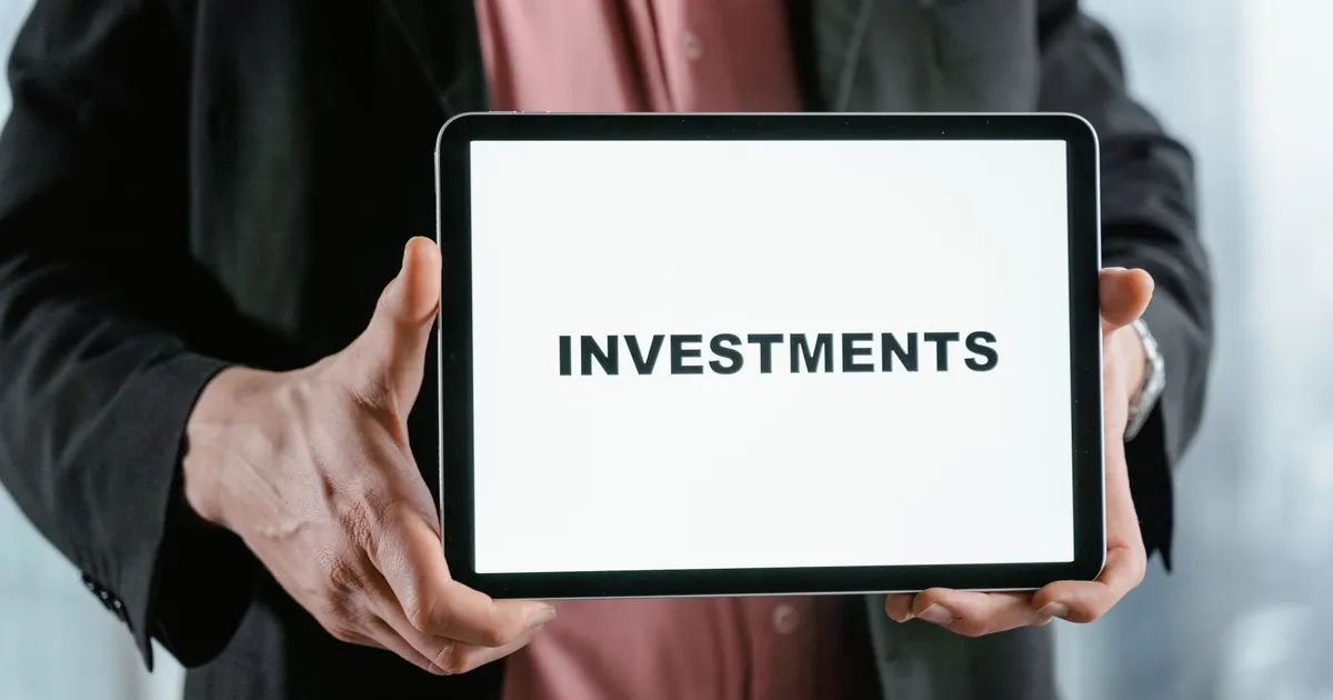 Homem de terno com tablet 'INVESTMENTS', contexto de carteiras e juros no mercado de Tesouro Direto e FIIs.