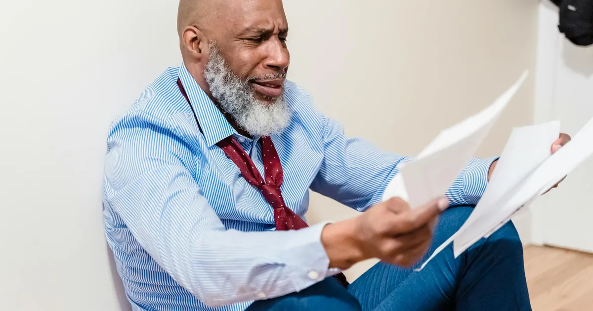 Daniel Vorcaro, Banco Master: Homem examina documentos, refletindo crise e investigação (FGC, PF).