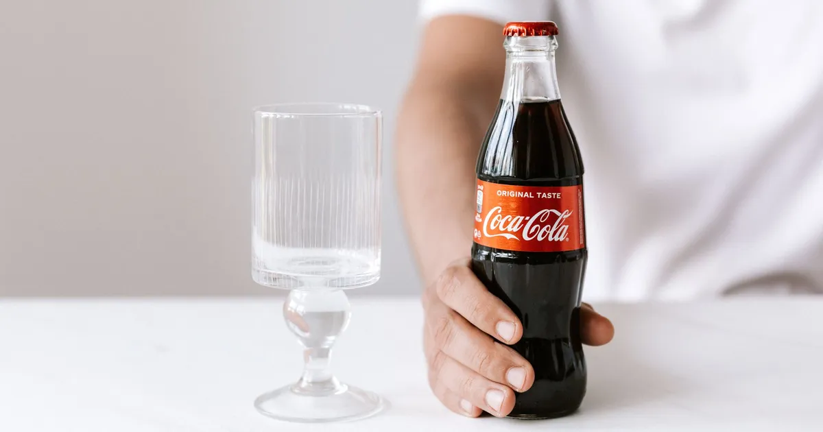Jovem com Coca-Cola, contexto de resultados corporativos TIM/Vivo no artigo.