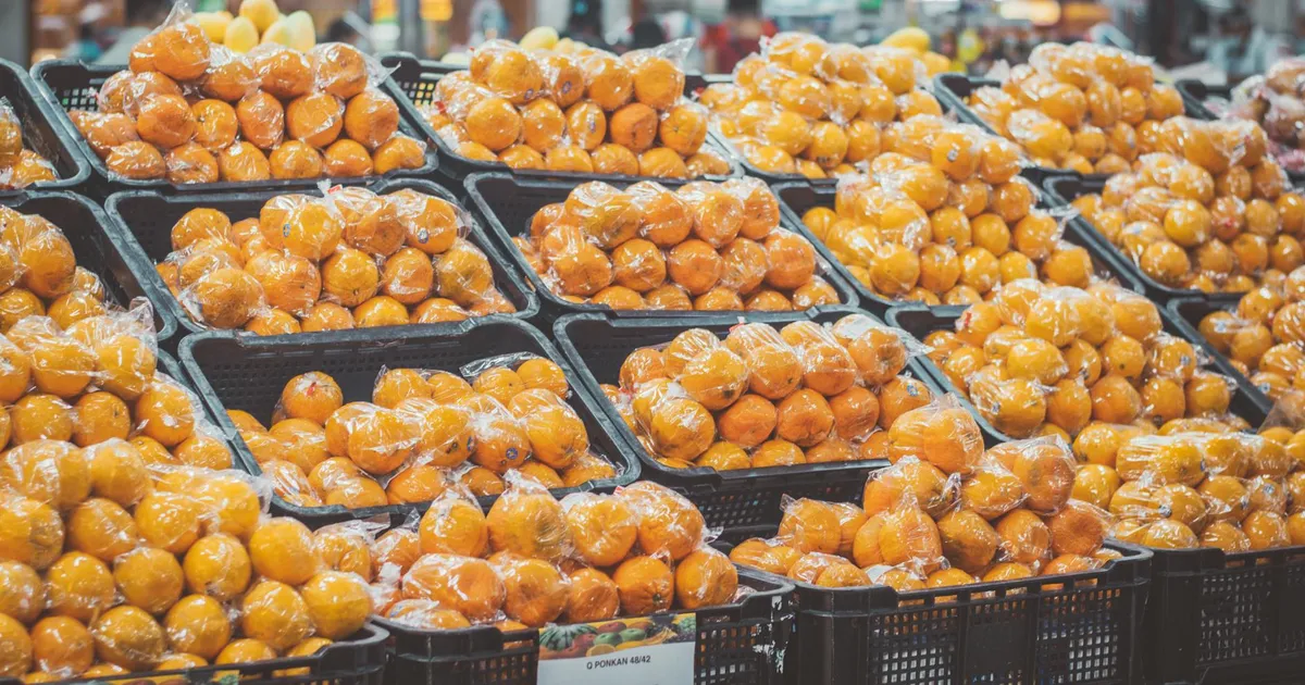 Laranjas embaladas no supermercado. Inflação e preços altos impactam a confiança do consumidor e a indústria.
