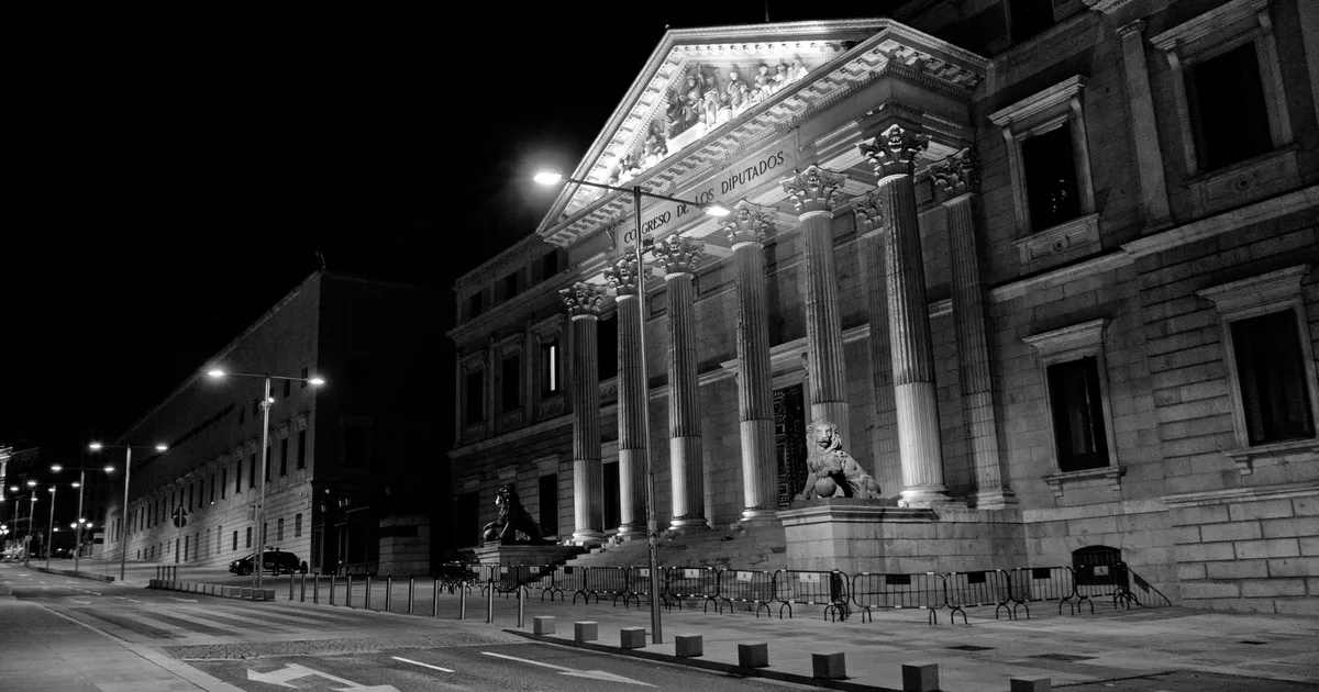 Congresso em recesso: Edifício do Congresso de Madrid à noite, simbolizando temas pendentes que afetam o bolso.