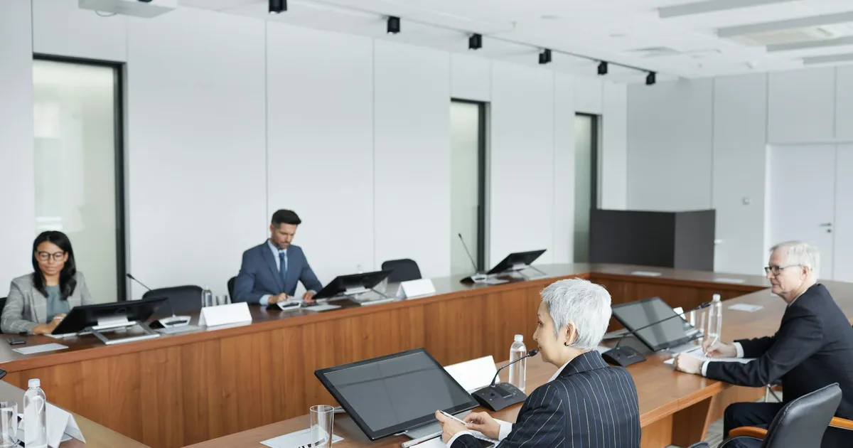 Reunião de profissionais discutindo inflação e política monetária em meio à turbulência do mercado de trabalho.
