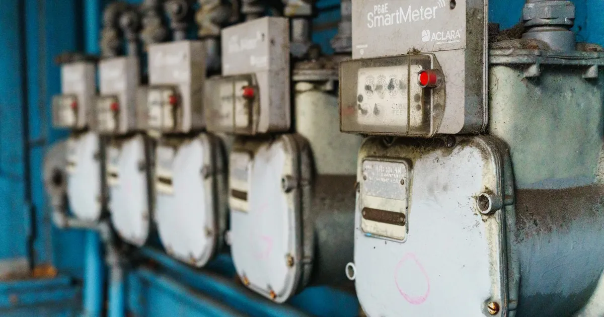 Múltiplos medidores inteligentes de energia na parede. Indicam a Bandeira Amarela da Aneel e o custo na conta de luz.