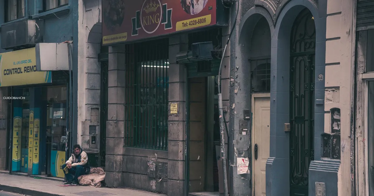 Argentina: Inadimplência impacta famílias. Rua urbana com comércio e pessoa refletem crise e perda do poder aquisitivo.