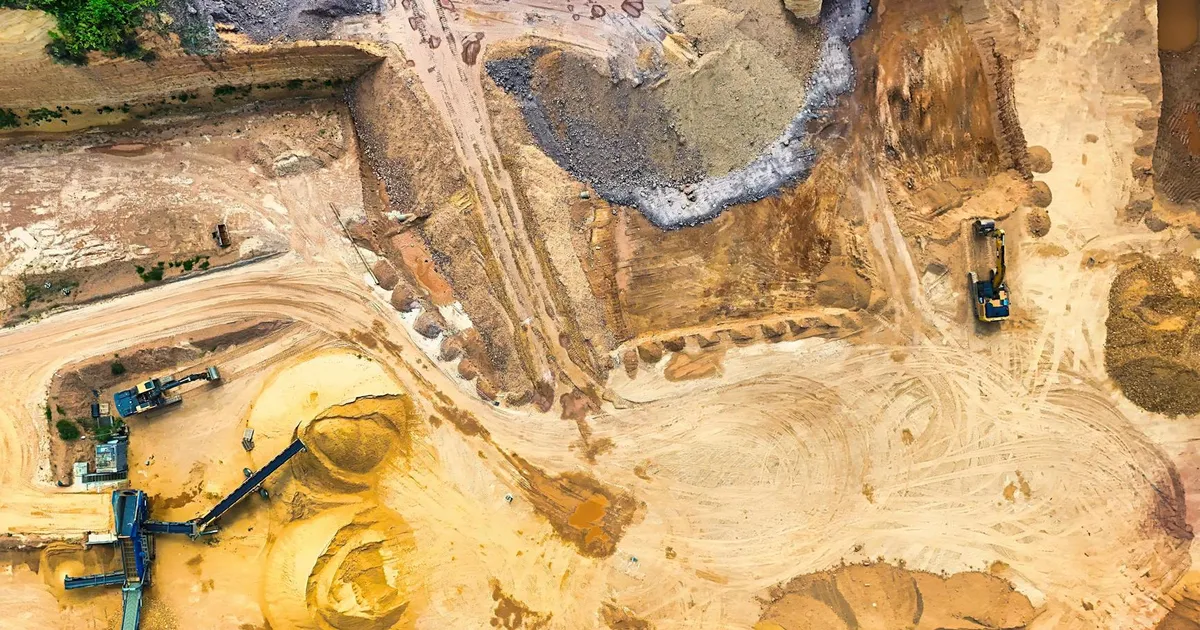 Vista aérea de mina com maquinário para extração de Terras Raras, no contexto da crise e venda sob ataque.