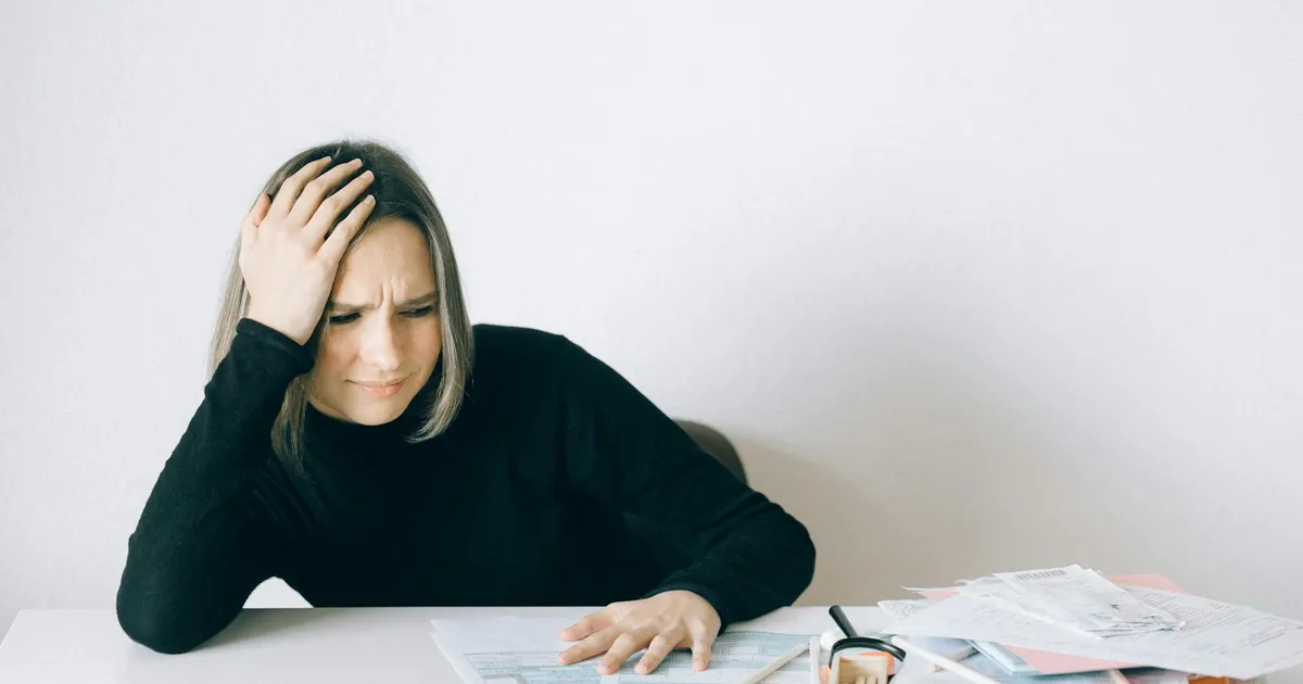 Endividada e estressada: mulher lida com contas e juros altos. Dívida familiar preocupa.