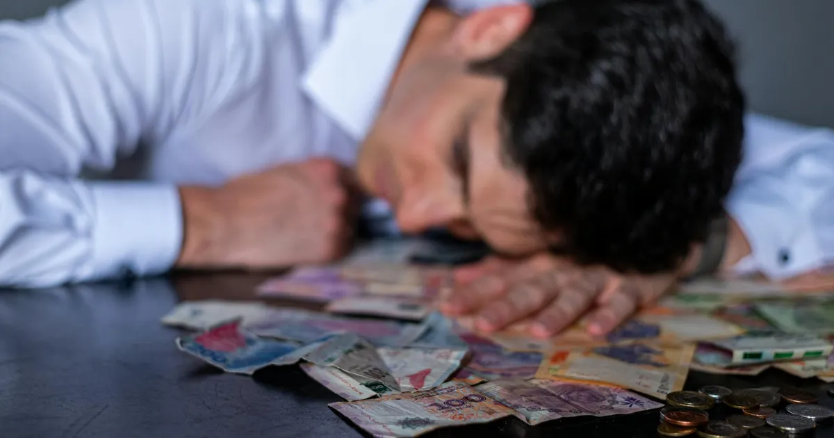 Endividado? Juros altos e inflação pesam no bolso: homem preocupado com dívidas e contas. Impacto financeiro.