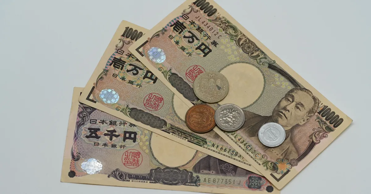 Notas e moedas de iene japonês em queda livre, contrastando com a força do dólar em R$5,17.