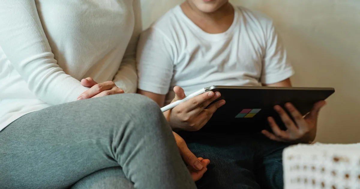 Mãe e filho usam tablet: segurança digital de crianças e adolescentes online, com foco na proteção de dados (ANPD).