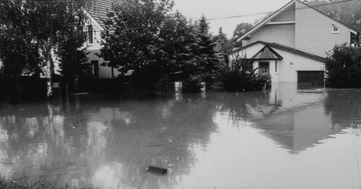 Rua inundada após El Niño: casas submersas em alerta de chuvas intensas e prejuízos econômicos.