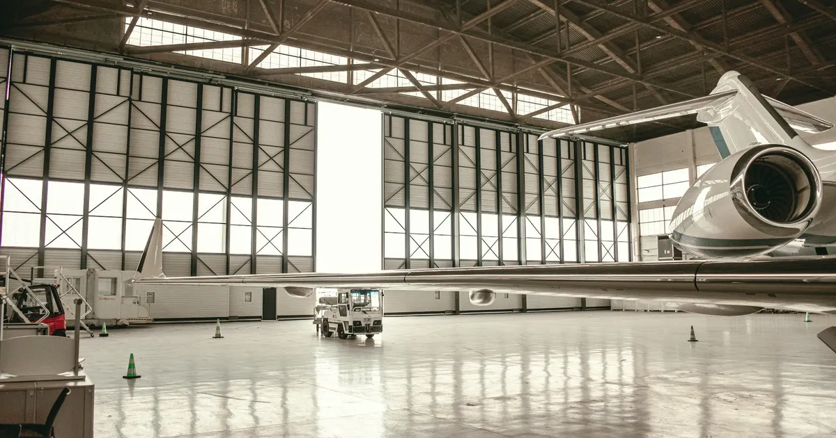 Jato executivo Embraer em hangar moderno. Desempenho Embraer e investimentos no mercado.