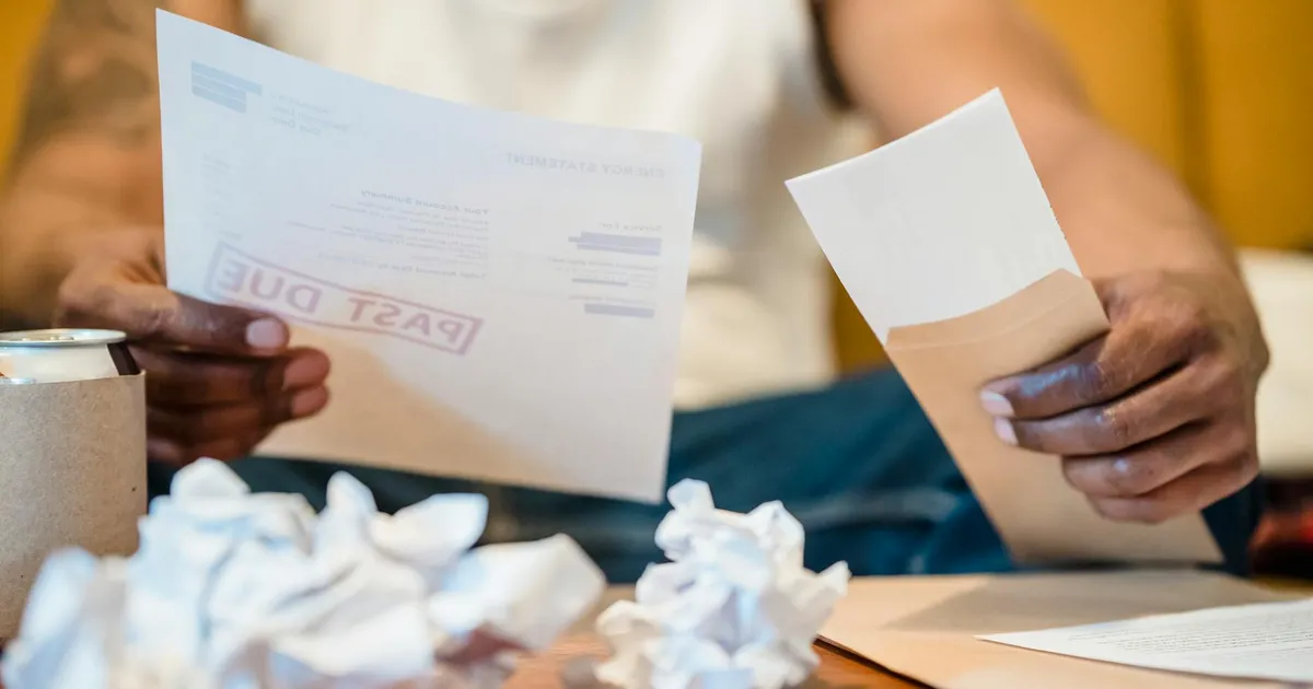 Homem analisa contas atrasadas. FGTS pode aliviar dívidas? Inflação e economia em debate.