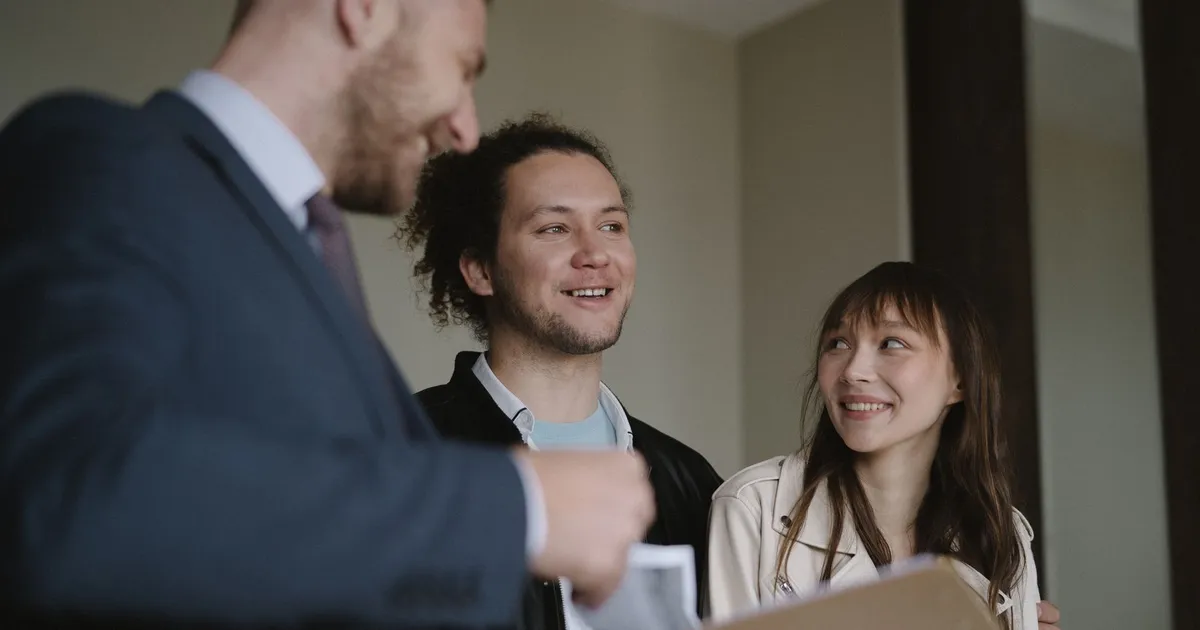 Casal feliz discute apartamento com corretor, animando cotistas FIIs EDGA11 e ZAGH11.