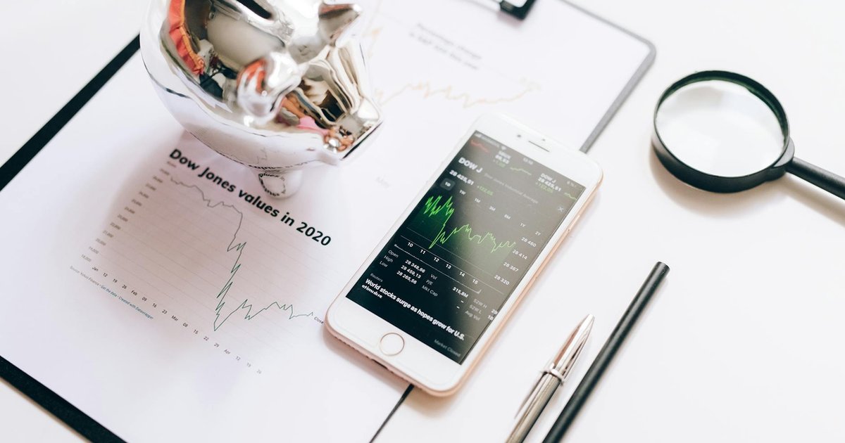 Ferramentas financeiras em flat lay: gráfico, celular, lupa e cofrinho, para o Guia Completo de Financiamento 2026.