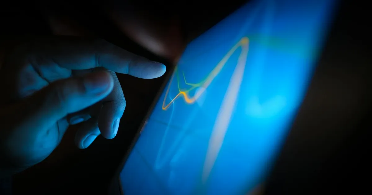 Mão monitorando gráficos em touchscreen sobre risco de crédito, economia global, dólar e alertas Fitch.