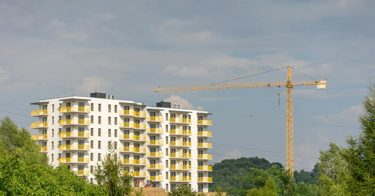 Fundo Imobiliário: Prédio moderno e construção em Trzebinia, Polônia, refletindo o mercado imobiliário.