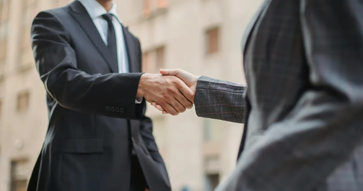 Aperto de mãos simboliza parceria e acesso a crédito para empresas via FGI e BNDES.