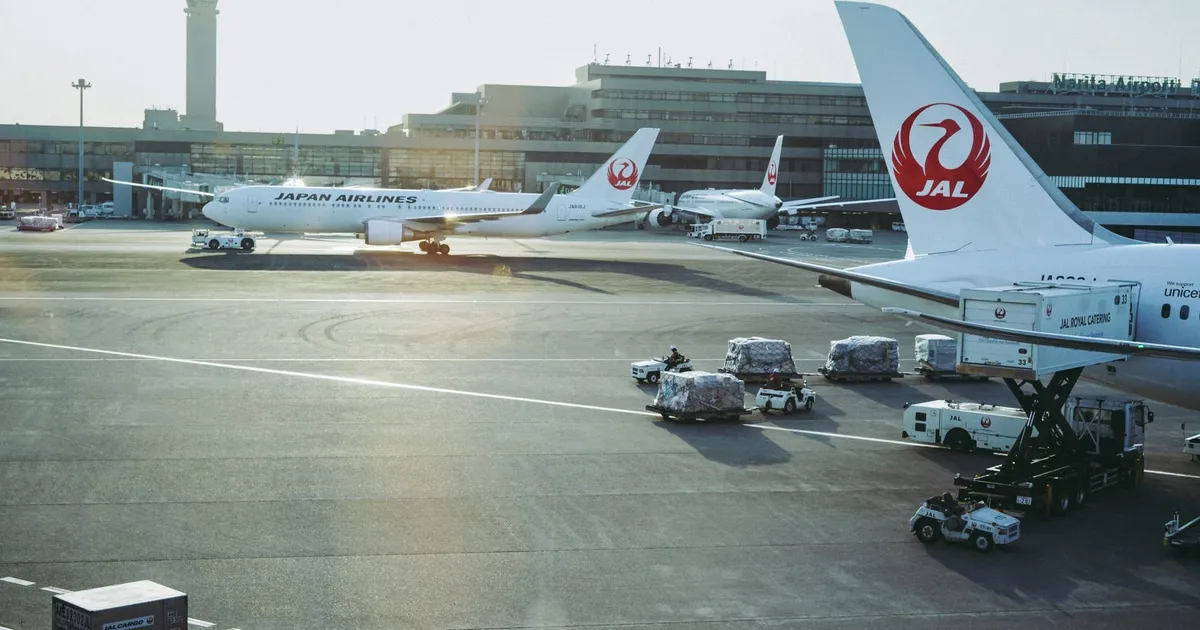 Aviões da Japan Airlines, simbolizando companhias aéreas, em aeroporto, contexto de investimento do governo.