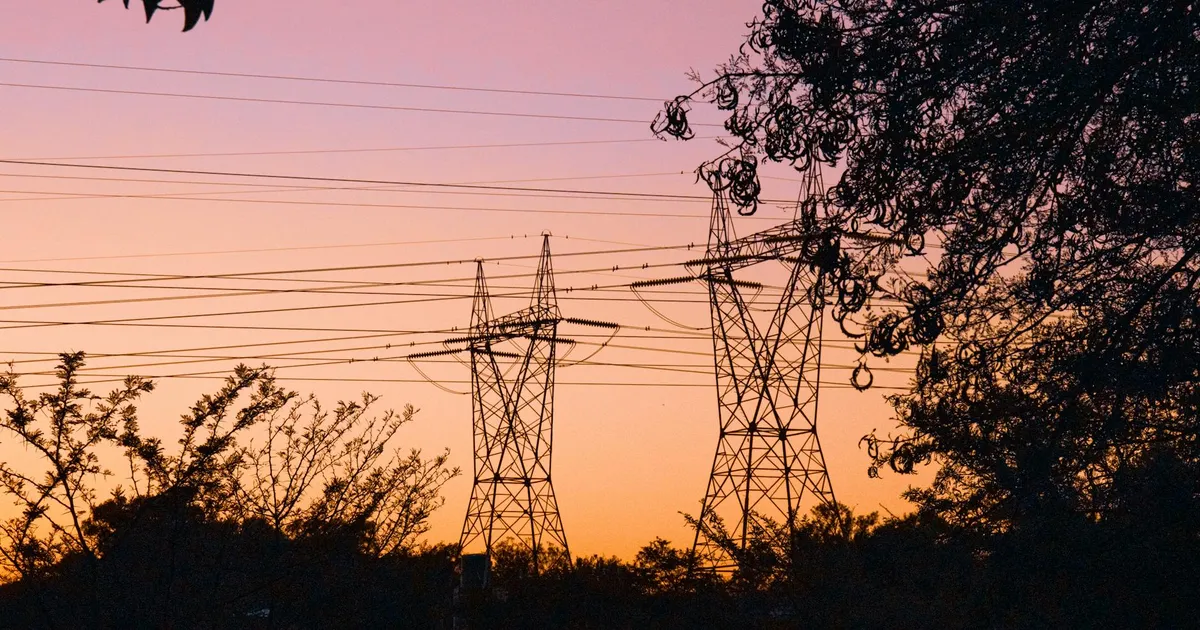 Crise energética: Torres de transmissão sob o pôr do sol. Impacto da guerra no Irã e inflação na conta de luz.