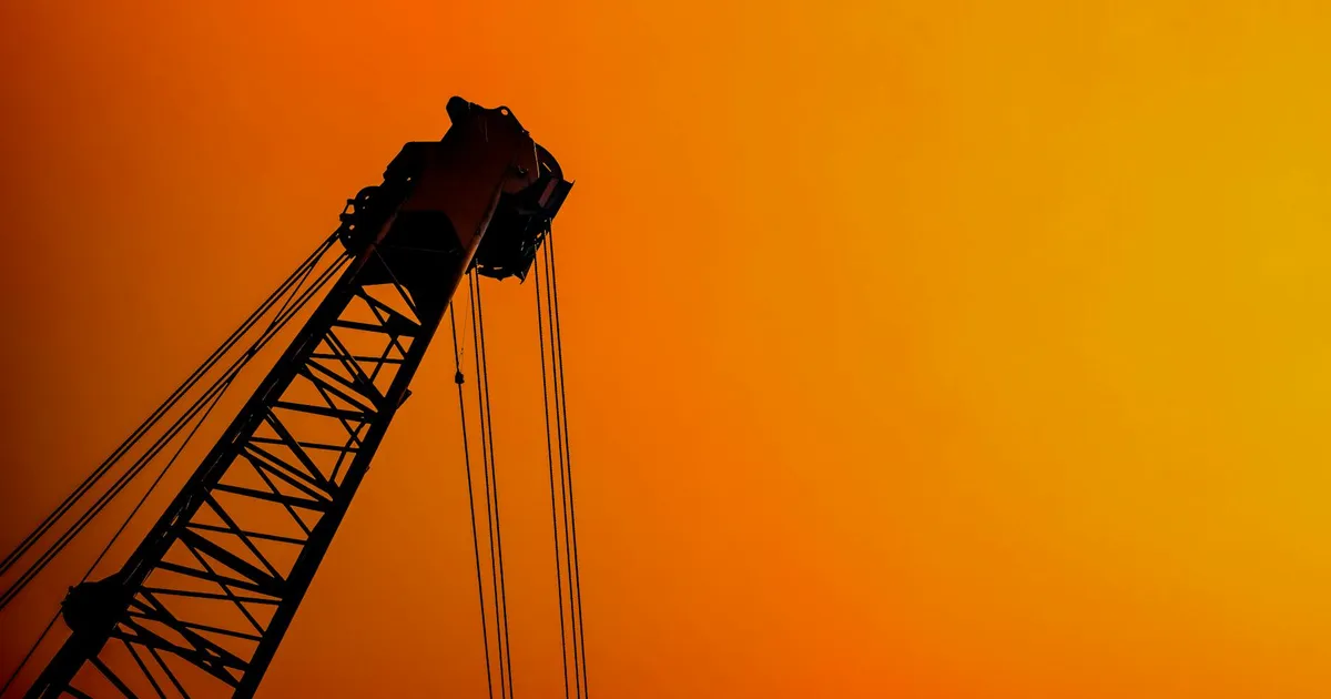 Impacto da guerra no Irã no mercado: Guindaste em silhueta com céu laranja, refletindo incerteza no Ibovespa, petróleo e d...