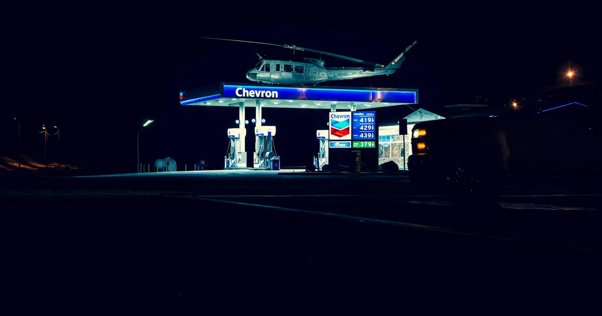 Guerra no Oriente Médio eleva preços: Gasolina da Chevron sob helicóptero ilustra impacto da inflação no Brasil.