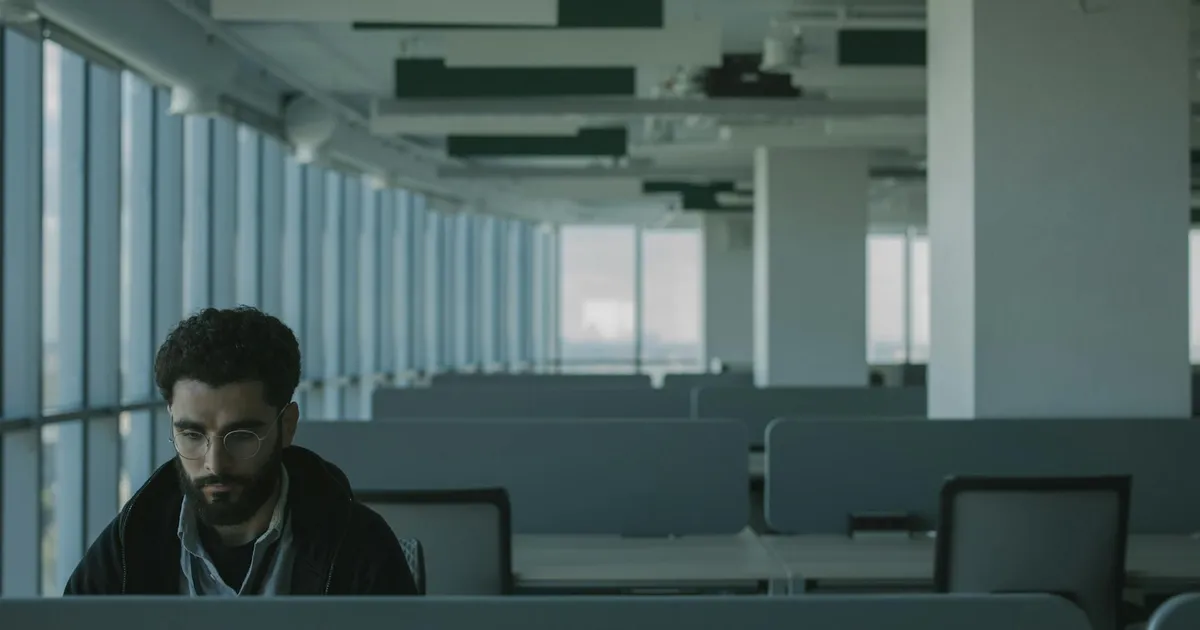 Homem sozinho no escritório. Demissões do Snapchat impactadas pela IA no mercado de trabalho.