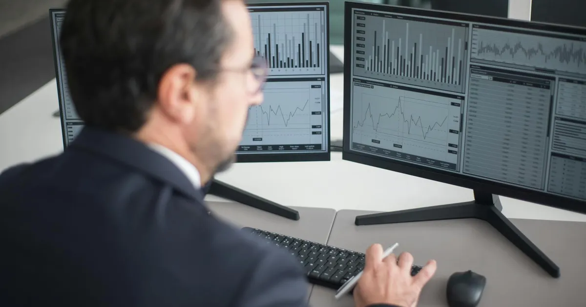 Empresário analisa gráficos de IA: ações sobem, custos da tecnologia em disputa.