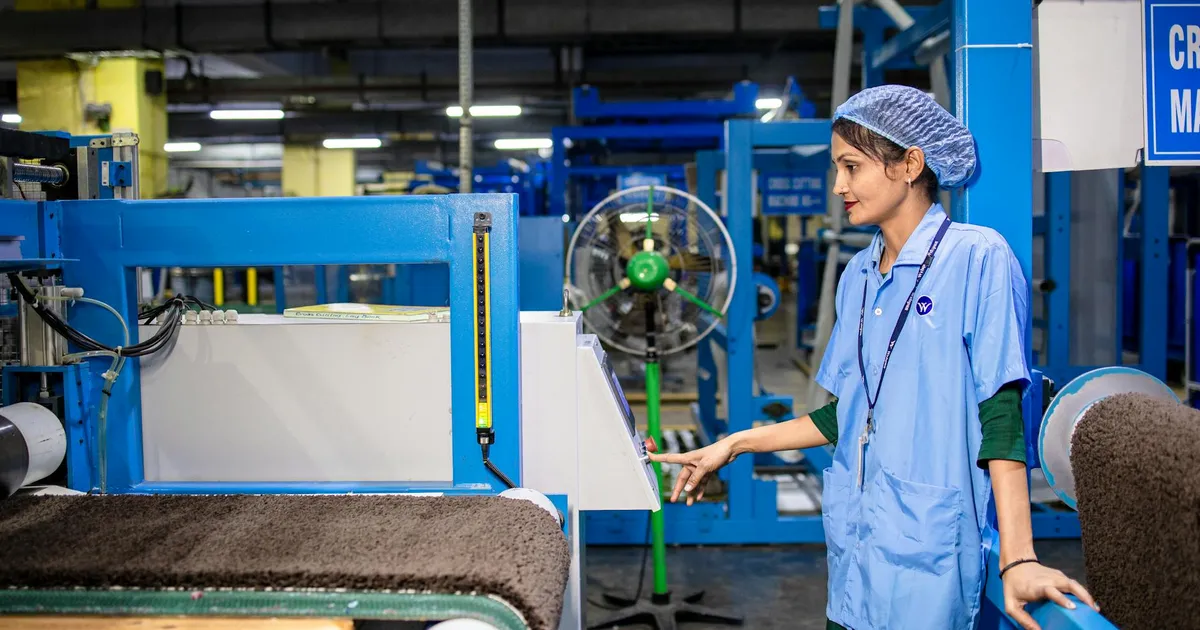 Trabalhadora em fábrica têxtil moderna: IA e o futuro do emprego, dívidas e FGTS.