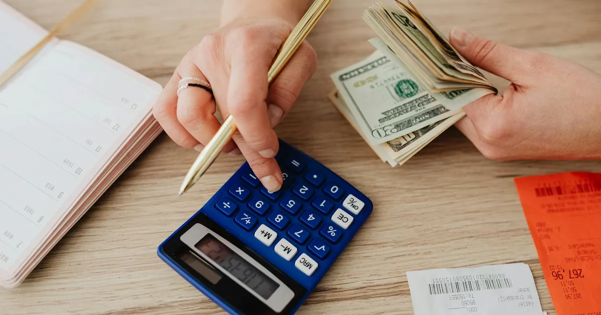 Planejamento financeiro 2026: mãos calculando orçamento familiar com inflação e IPCA no Brasil.