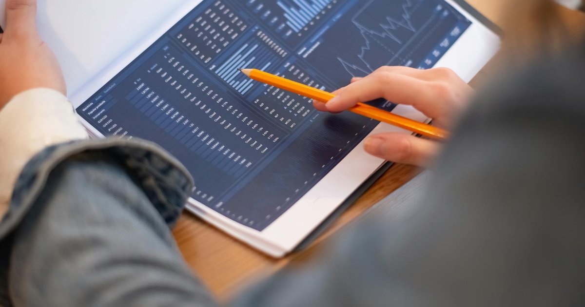 Mãos focadas em gráficos e dados de negócios. Ilustra a análise de compliance LGPD em inglês para empresas.