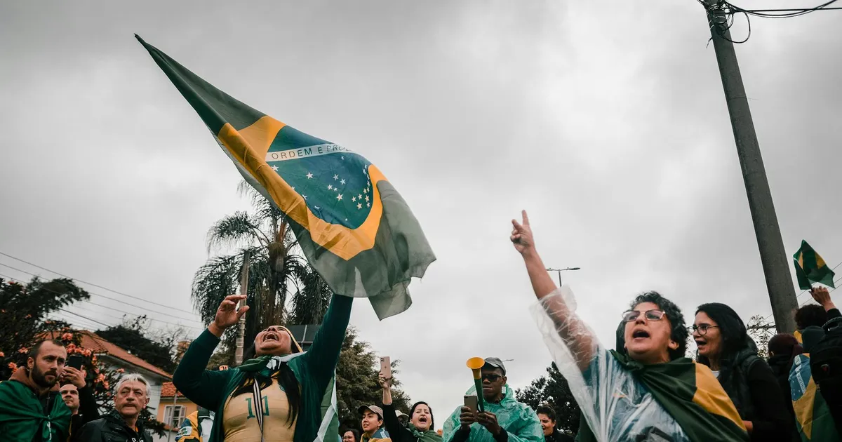 Manifestação pró-Lula com bandeiras do Brasil. Economia e eleições 2026 no radar.