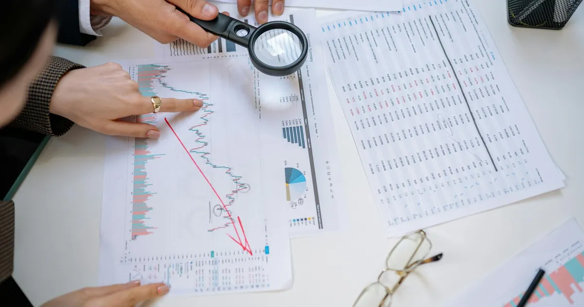 Especialistas em análise de ações examinam documentos financeiros. Essencial para Klabin, MRV e Fundos Imobiliários.