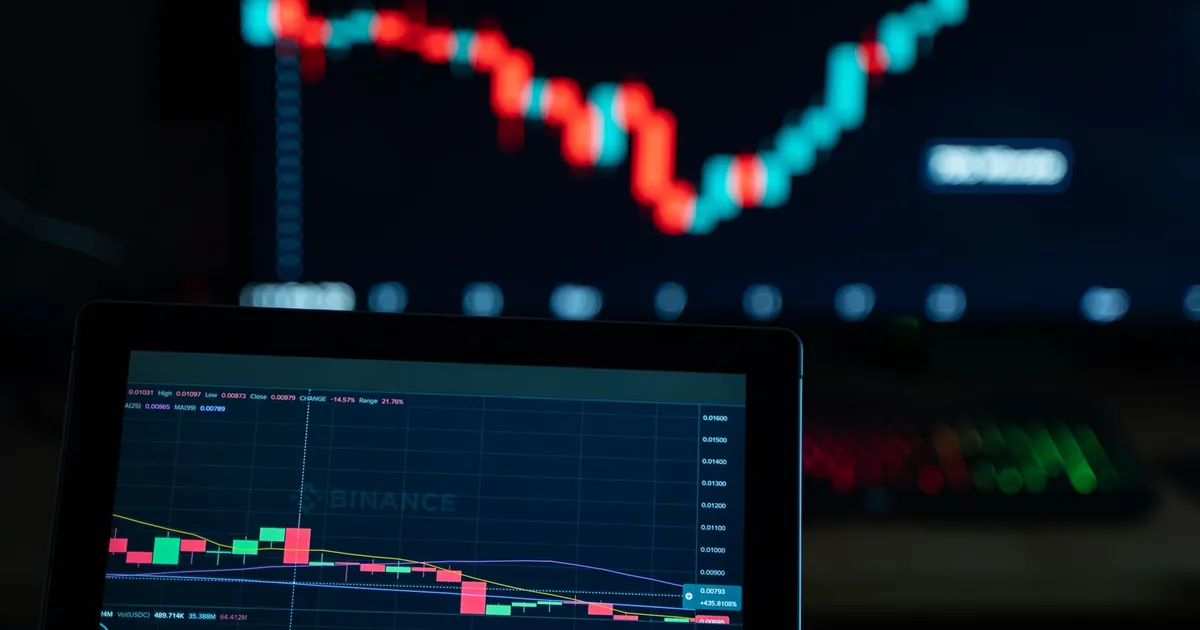 Gráficos de trading cripto em telas, refletindo flutuações dos mercados e olho nos EUA.
