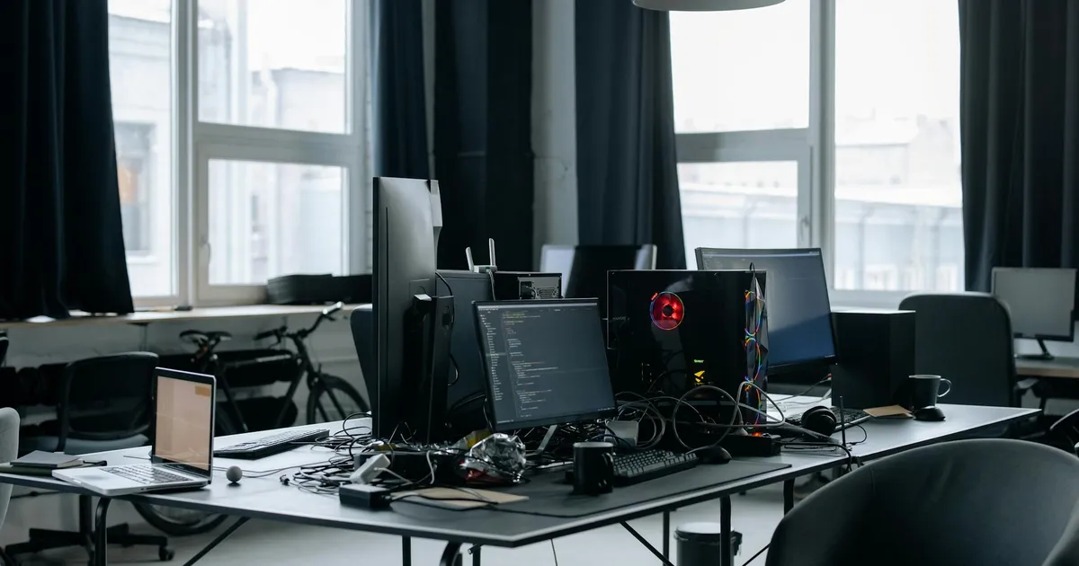 Mercado tech: ambiente de trabalho com computadores e código, refletindo desafios da Meta e do setor.