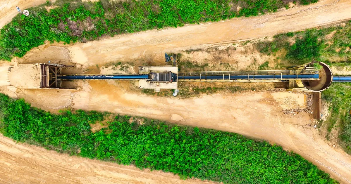Mineração: sistema de esteira industrial da Vale e CSN entre campos verdes.