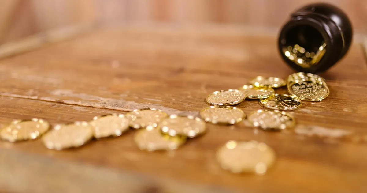 Ouro fecha semana no azul: Moedas douradas simbolizam valor em meio à cautela geopolítica e inflação.