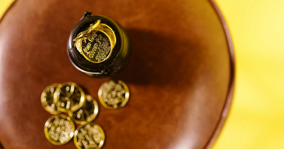 Ouro em queda: moedas douradas simbolizam a análise de investimentos e a hora de repensar a estratégia.