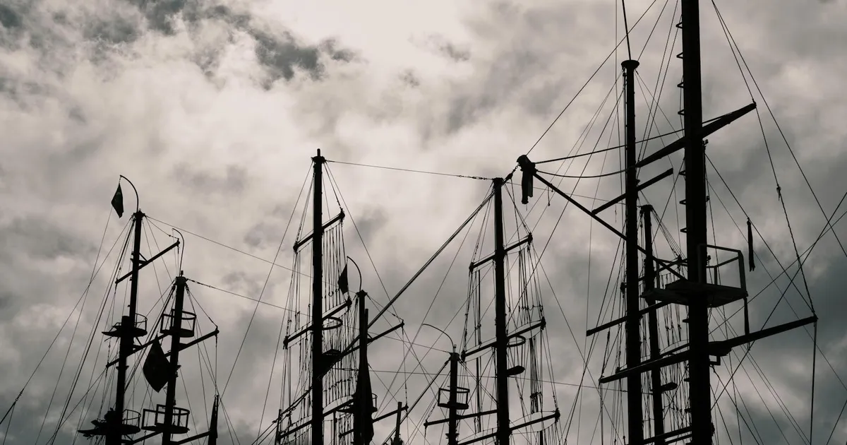 Céu nublado e mastros de barcos refletem a incerteza no Ibovespa com a queda do petróleo.