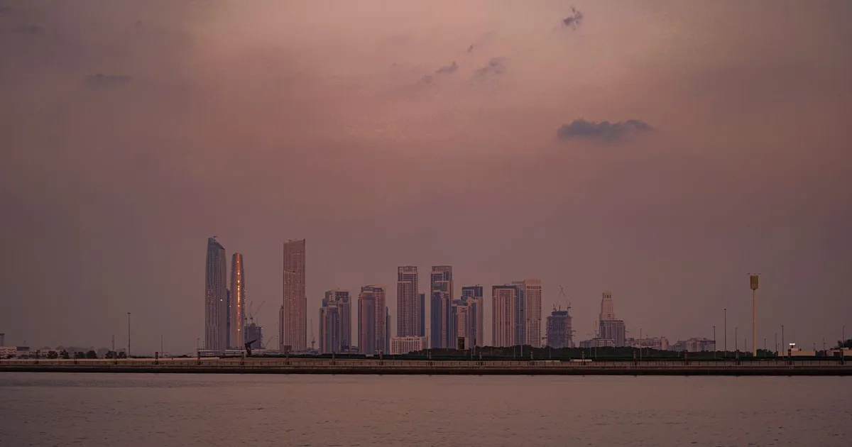 Dubai: skyline crepuscular com mar calmo e arranha-céus, refletindo impacto do petróleo EUA-Irã no Brasil.