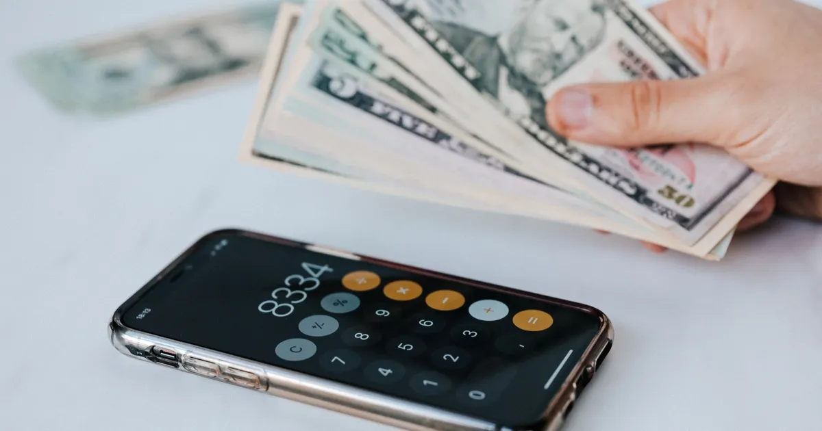 Tela de celular com app de calculadora e dinheiro, simulando pagamentos ágeis com Pix Pensão.