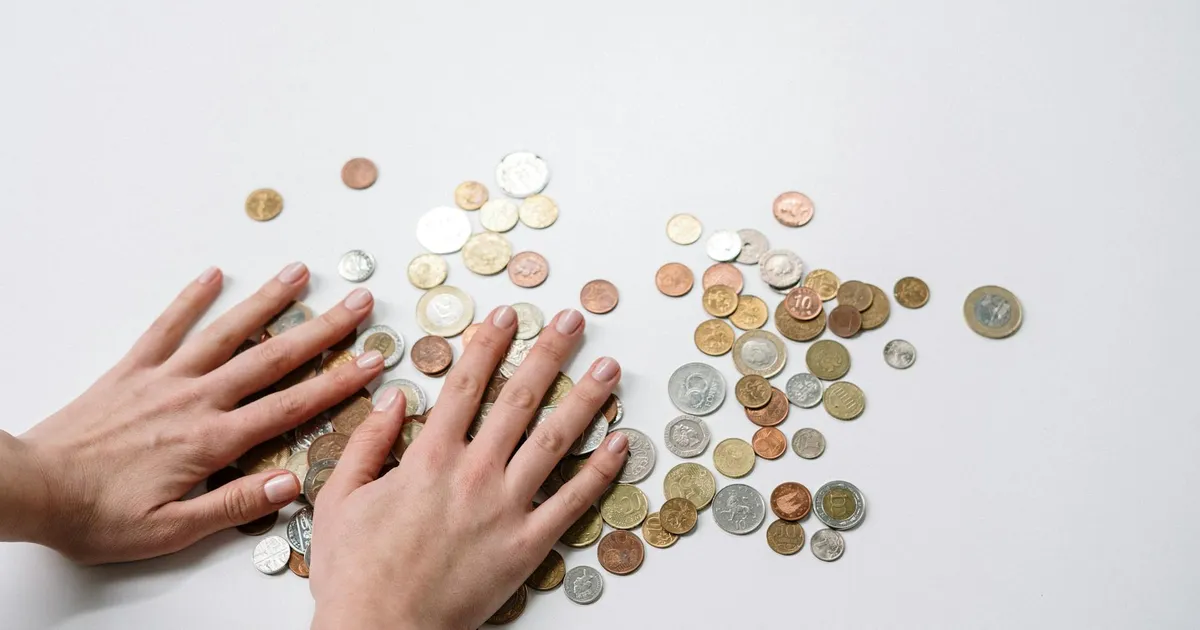 Moedas internacionais em mãos, refletindo a desigualdade social e a renda média no Brasil.